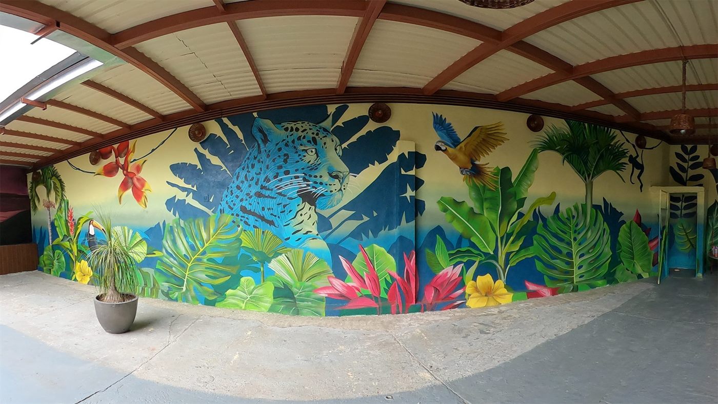 Terraza residencial con muros pintados como una selva: jaguar, tucán y follaje a escala